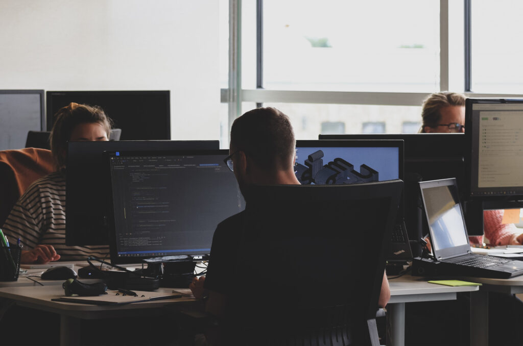 Photographie de plusieurs personnes travaillant dans des bureaux type "open space". Ceux-ci travaillent sur la valorisation d'entreprise.